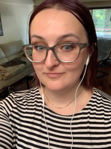 A photograph of myself wearing a black and white striped shirt and my headphones. I am wearing the necklace I reference: it is a black cord with small gold dots and dashes.
