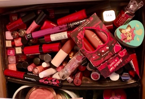A top down photograph of my lip products. There are lipsticks and glosses piled into a messy box.