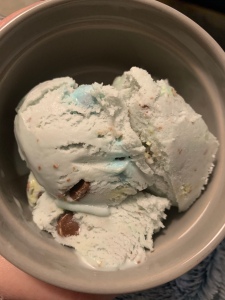 A top down photo of a light blue ice cream with chopped mini eggs.